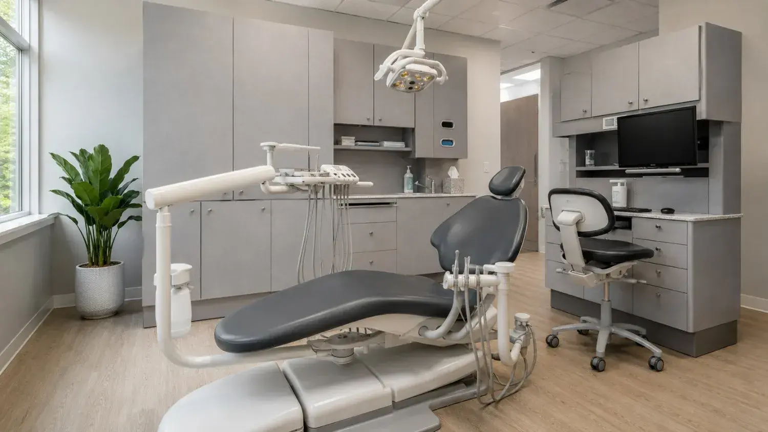 A bright modern dental operatory with a contemporary dental chair and neutral cabinetry